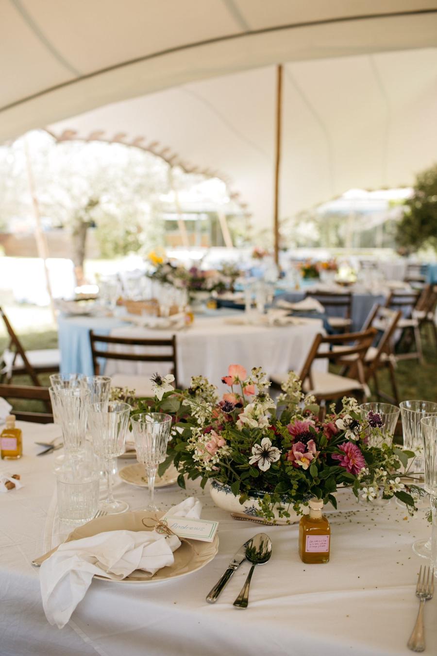 Banquete bajo carpa con mesas de flores en una destination wedding en la Costa Brava, publicada en Vogue