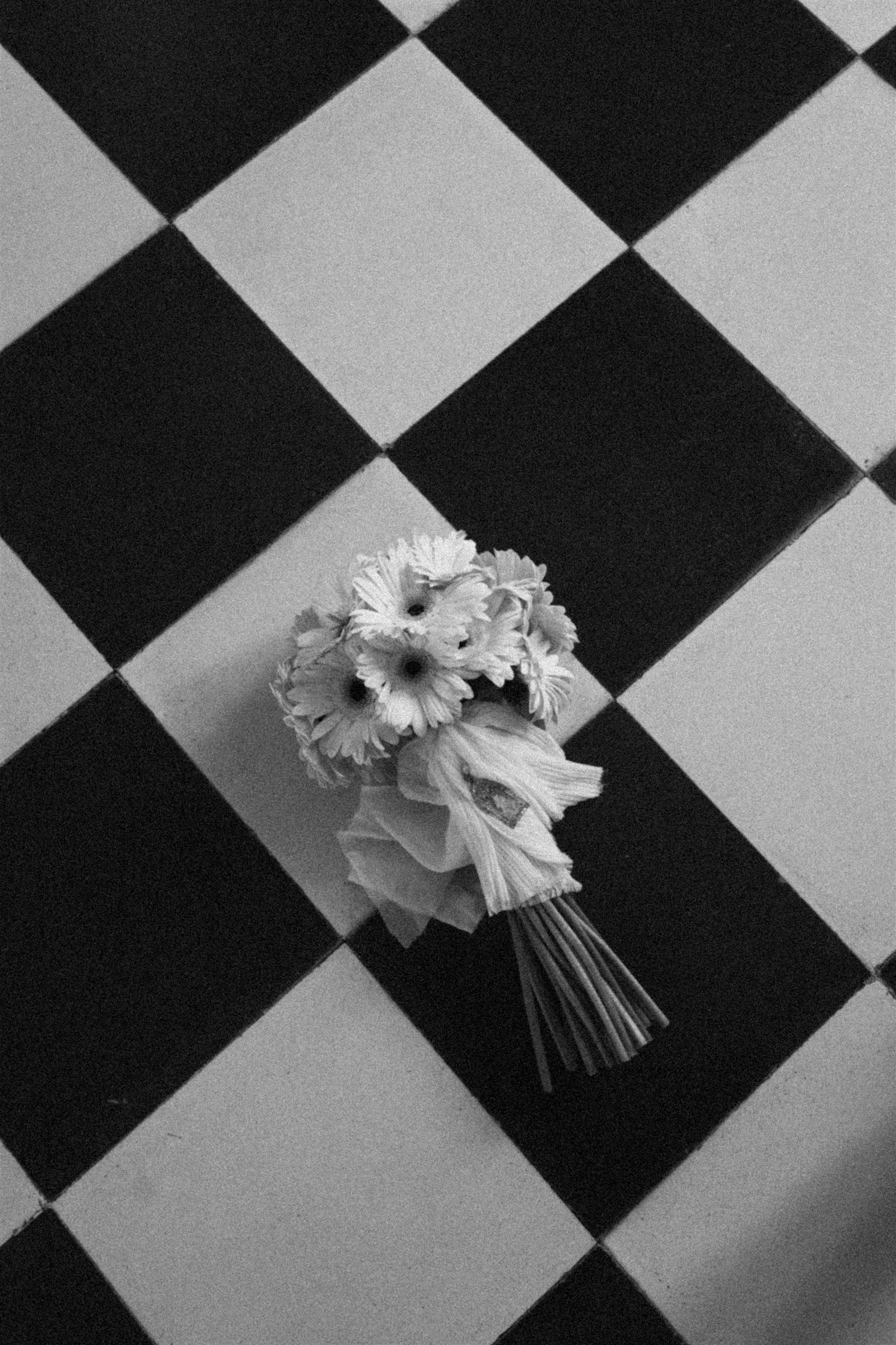 Suelo de baldosa hidráulica en blanco y negro con el ramo de la novia